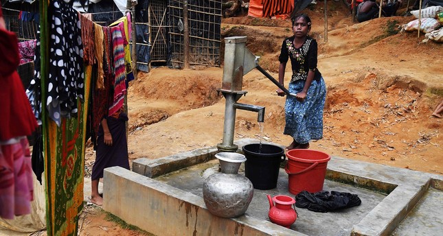 This picture taken November 4, 2017 shows ten-year-old Rohingya refugee Tahera Begum collecting water from a hand-pump at the Balukhali refugee camp in Bangladesh's Ukhia district (AFP Photo)