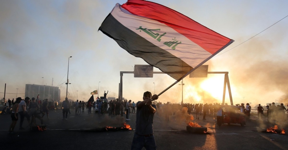 An Iraqi protester waves the national flag during a demonstration against state corruption, failing public services, and unemployment, in the Iraqi capital Baghdad on Oct. 5, 2019. (AFP Photo)