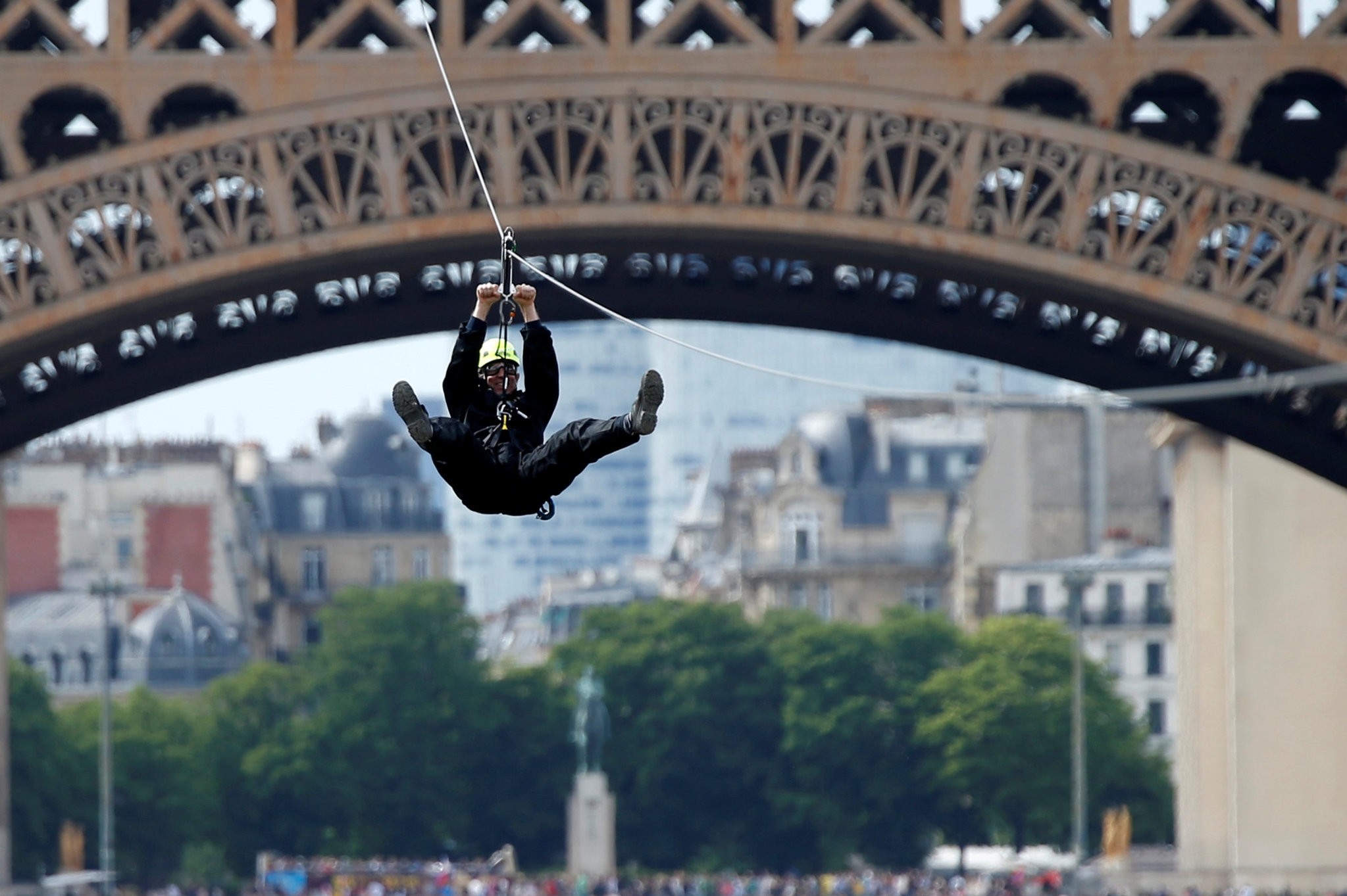 A participant rides a zip line from the 2nd floor of the Eiffel Tower, 115 metres above the ground along an 800-metre long route, as part of a free event operating until June 11 in Paris, June 4, 2017. (AFP Photo)