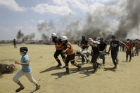 Palestinian medics and protesters evacuate a wounded young man during a protest at the Gaza Strip's border with Israel, east of Khan Younis, May 14.
