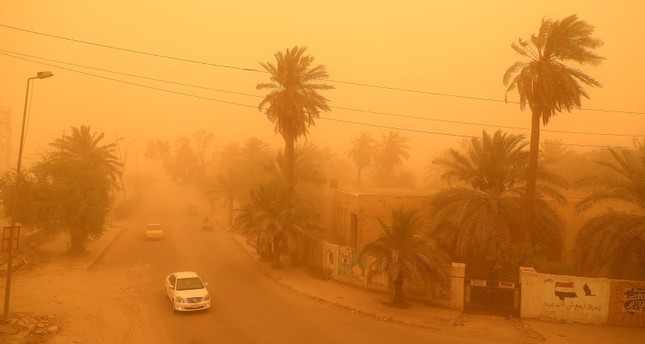 مرور المركبات وسط عاصفة ترابية شديدة في مدينة الناصرية بمحافظة ذي قار جنوب العراق في أيار / مايو AFP