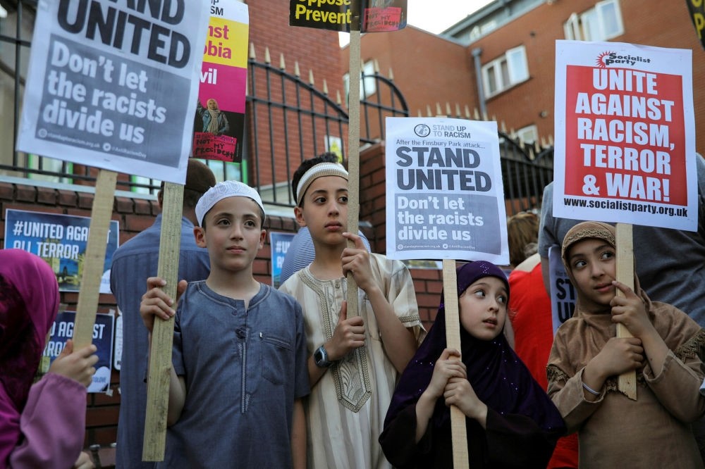 Children hold placards during a vigil near to where a van was driven at Muslims in Finsbury Park, North London, Britain, June 20.