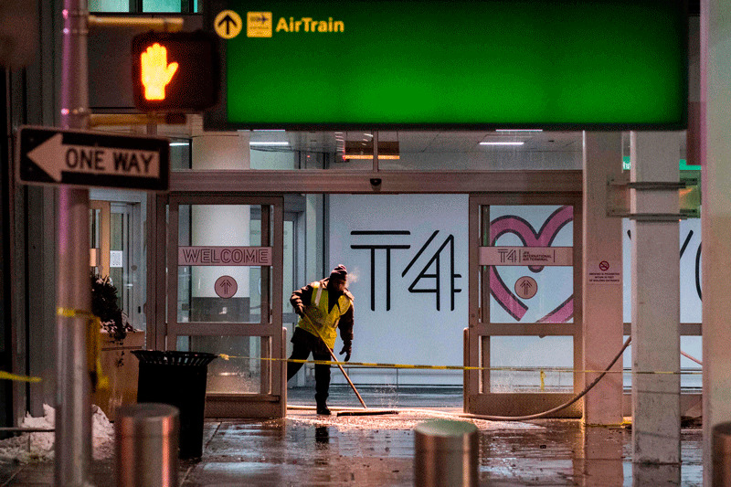 Workers sweep water from the floor of the arrivals area at John F. Kennedy International airport's terminal 4, in New York (AFP Photo)