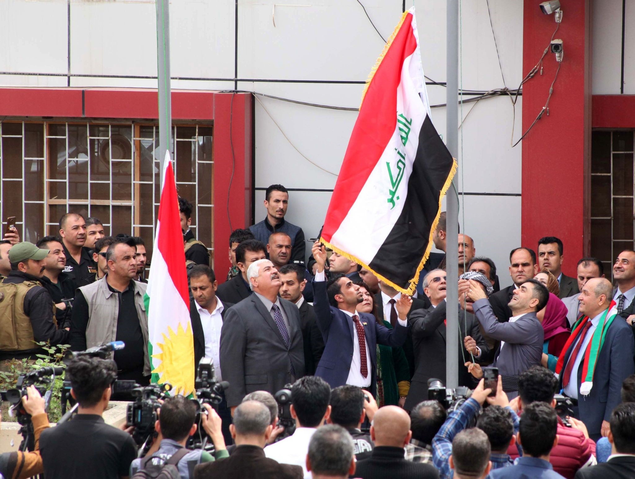 Kirkuk provincial governor raises the Iraqi flag to fly next to the Kurdish flag over a government building in Kirkuk on March 28, 2017. (AFP PHOTO)