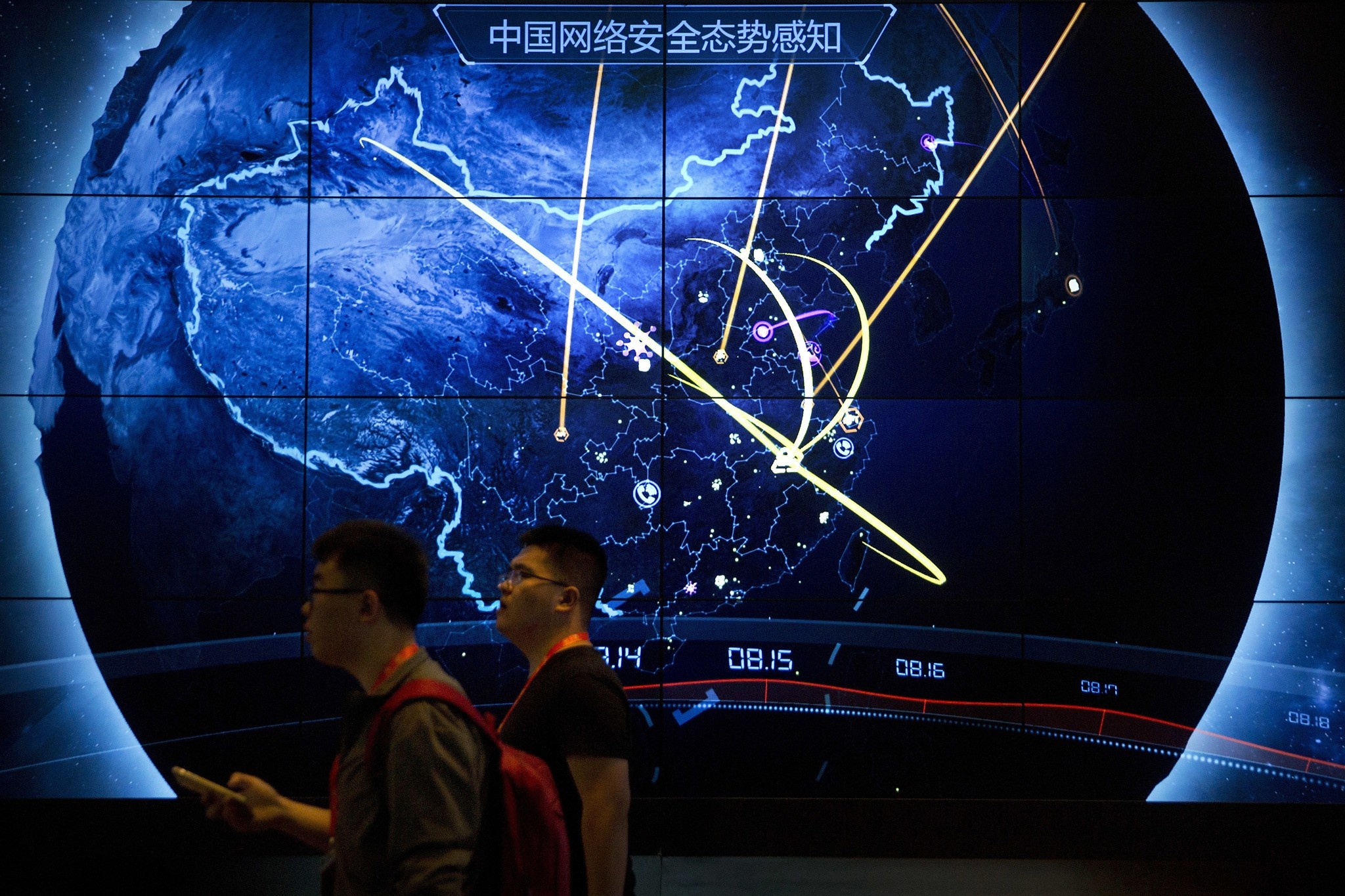 Attendees walk past an electronic display showing recent cyberattacks in China at the China Internet Security Conference in Beijing, Tuesday, Sept. 12, 2017. (AP Photo)