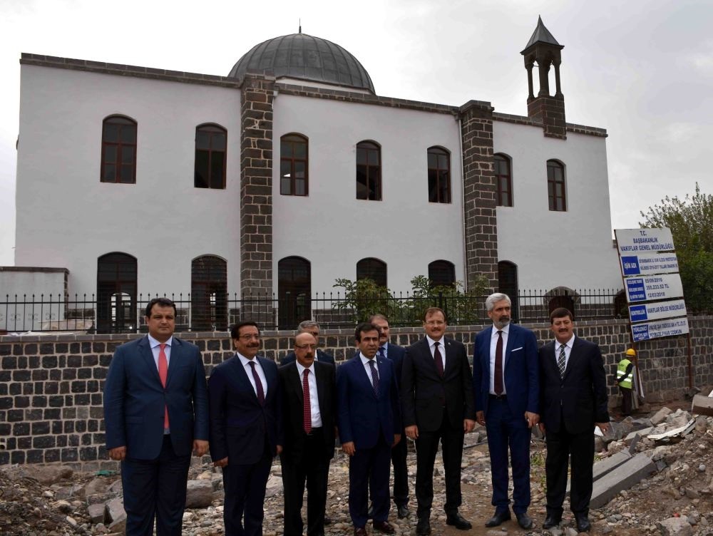 Deputy Prime Minister Hakan u00c7avuu015fou011flu and local officials pose in front of the restored church during a recent visit.