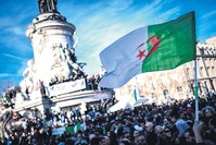 A protester holds up the Algerian flag during a rally against the Algerian president's bid for a fifth term in office, at the Place de la Republique in Paris, February 24, 2019.