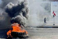 An Iraqi demonstrator walks past burning tires as they block a road during an anti-government protest, Nassiriya, Jan. 27. (REUTERS Photo)