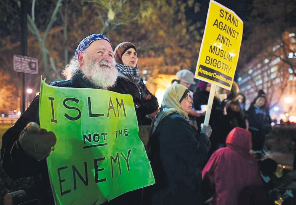 A man holds a placard during a vigil for three young Muslims killed in Chapel Hill, North Carolina, Feb. 12, 2015.