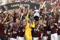 Players from Brazil's Flamengo celebrate on the podium with the trophy after winning the Copa Libertadores final football match by defeating Argentina's River Plate, at the Monumental stadium in Lima, on November 23, 2019. (AFP Photo)