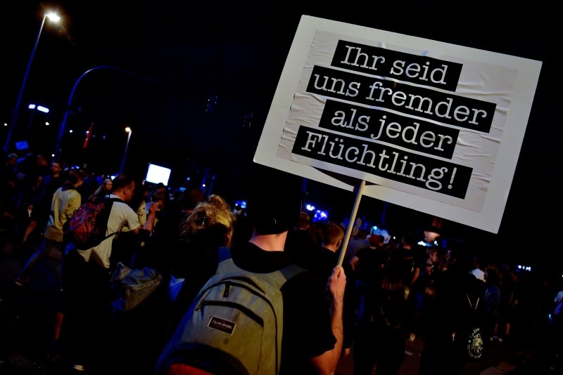 A man holds up a placard which reads 