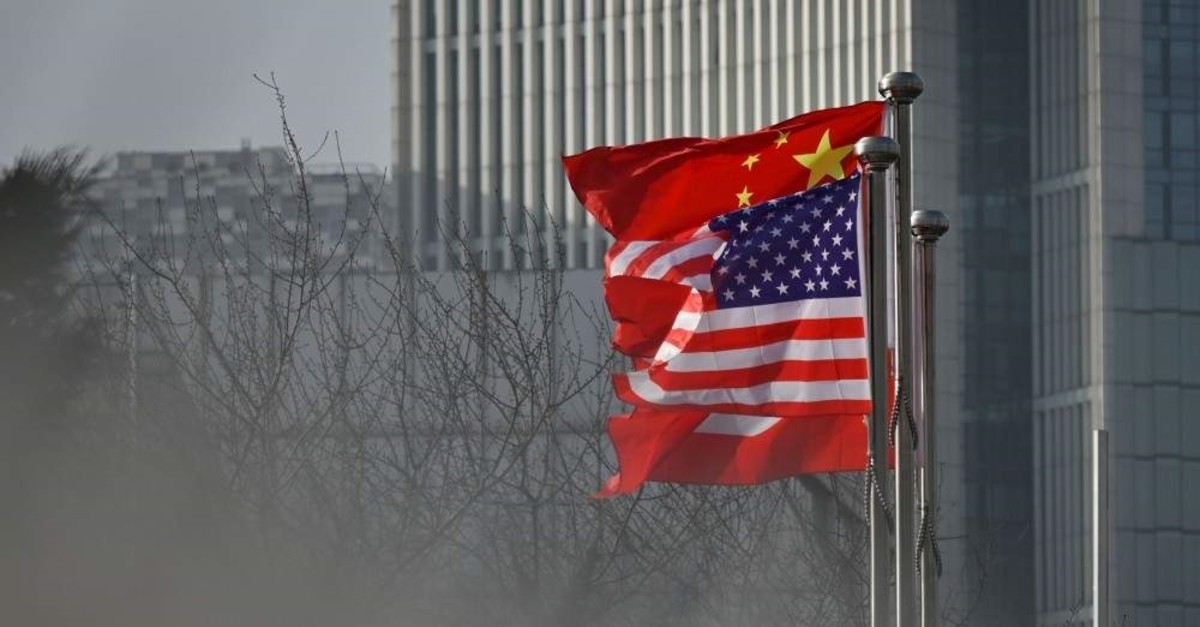 Chinese and U.S. national flags flutter at the entrance of a company office building in Beijing, Jan. 19, 2020. (AFP Photo)