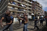 Opposition protesters throw rocks at riot police by hand and with slingshots during clashes with police in Nairobi, Oct. 26.