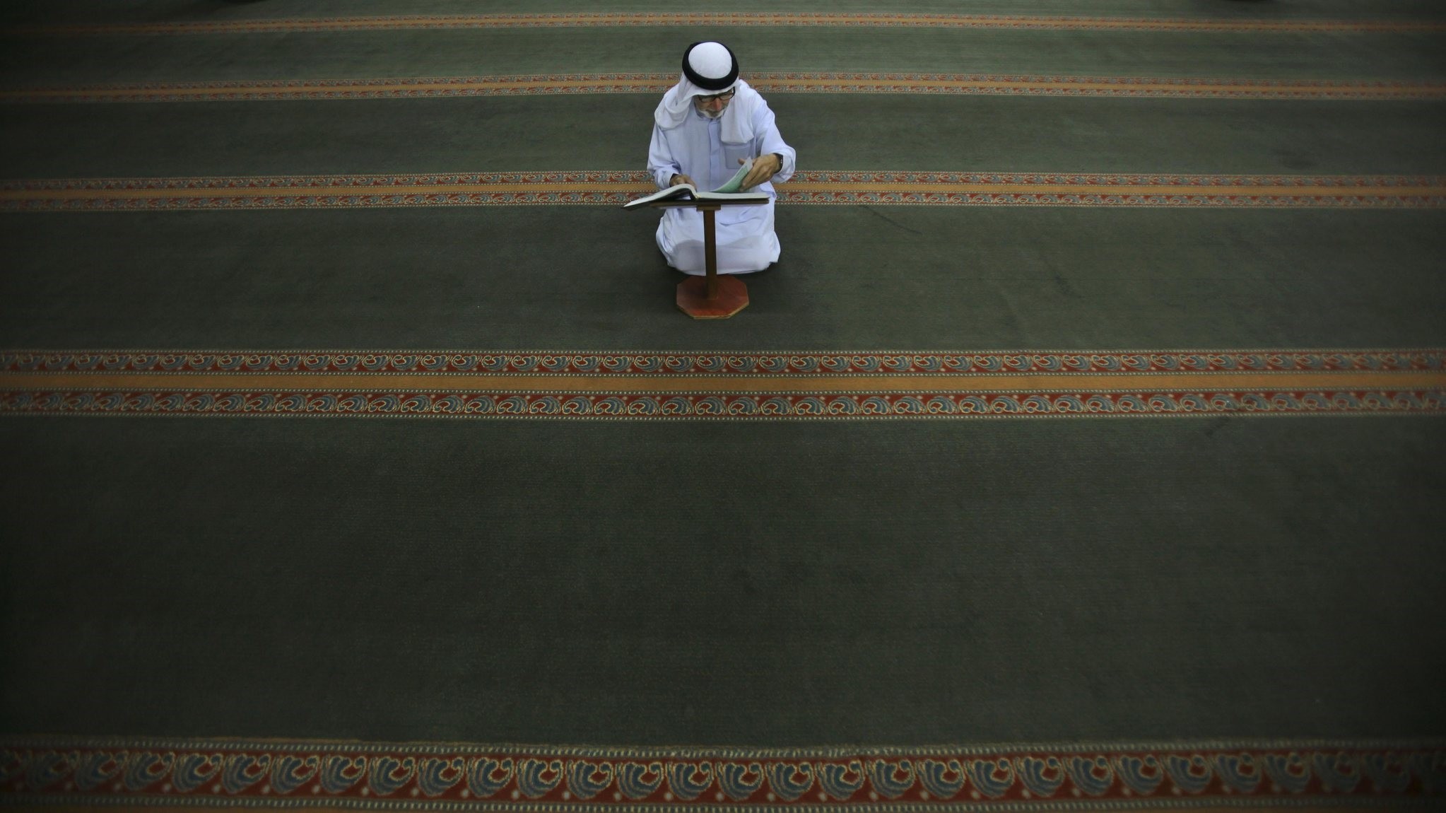 An elderly Palestinian Muslim man reads the Quran following the early morning prayer on the last day of the holy month of Ramadan at a mosque in West Bank, Ramallah, Sept. 9, 2010.