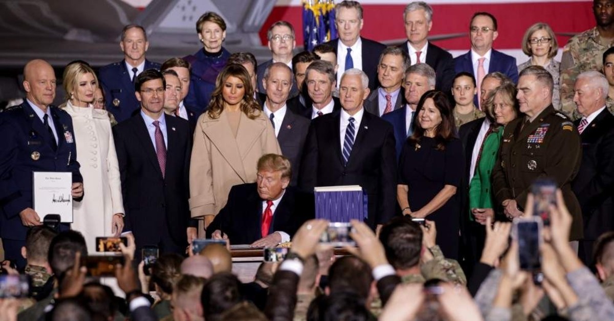 Encircled by top officials of his administration, US President Donald Trump signs $738 billion 2020 National Defense Authorization Act (NDAA) at Joint Andrews Base in Maryland, on Dec. 20, 2019. (AA Photo)