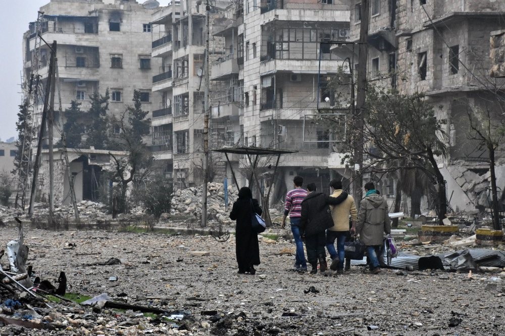 Syrian residents leave Aleppo's Bustan al-Qasr neighborhood following a clash between regime and opposition groups, Dec. 13, 2016.Photograph by AFP