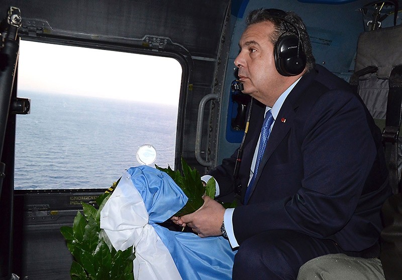 Greek Defense Minister Panos Kammenos prepares to throw a wreath over the area of the Imia Islets in the Agean Sea from a helicopter on Feb. 2, 2017. (AFP File Photo)