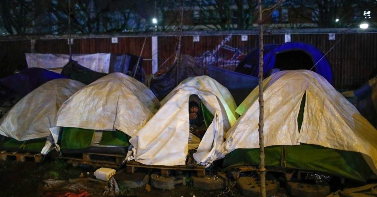 A migrant sits in his tent during the evacuation of a makeshift camp set up near the La Porte d'Aubervilliers, Paris, Jan. 28, 2020. (REUTERS Photo)