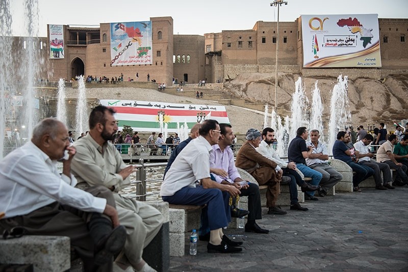This file photo shows people sitting in a central square in KRG capital Irbil with the city's historic citadel seen in the background, on Sept. 25, 2017. (Photo: Yunus Paksoy / Daily Sabah)