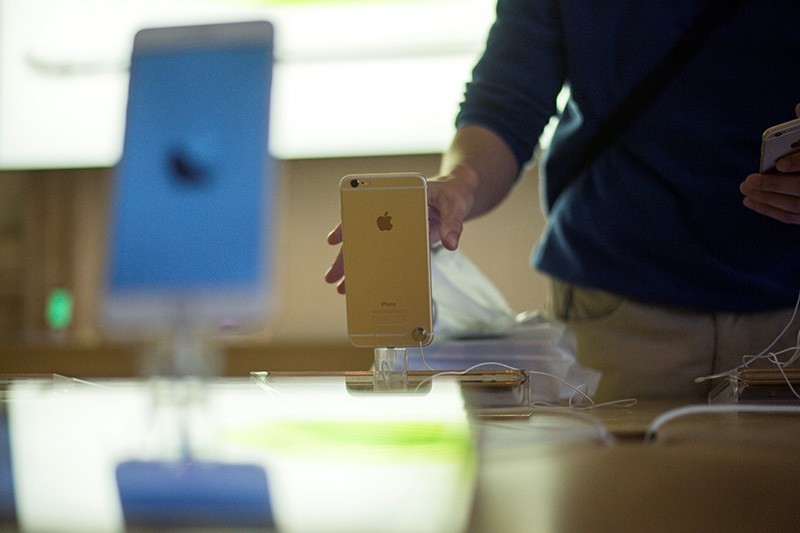 In this Sept. 19, 2014 file photo, a man checks an iPhone 6 on the day of its launch at the Apple Store in Pari, France. (AFP Photo)