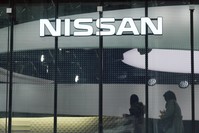Visitors walk near the logo of Nissan at a Nissan showroom in Tokyo, Nov. 22, 2018.