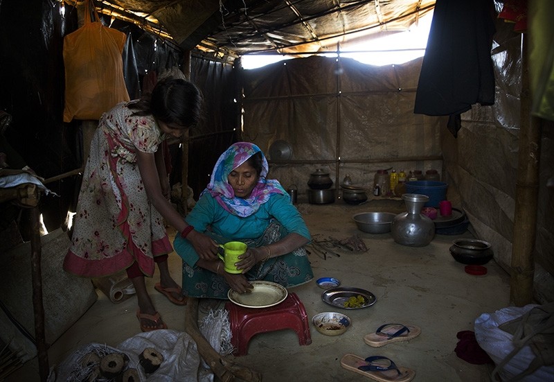 In this Jan. 28, 2018 photo, Rohingya Muslim refugees Nooranksih, 9, left, and her mother Rohima Khatu, 45, originally from the Myanmar village of Gu Dar Pyin, eat inside their makeshift shelter at Balukhali refugee camp, Bangladesh. (AP Photo)