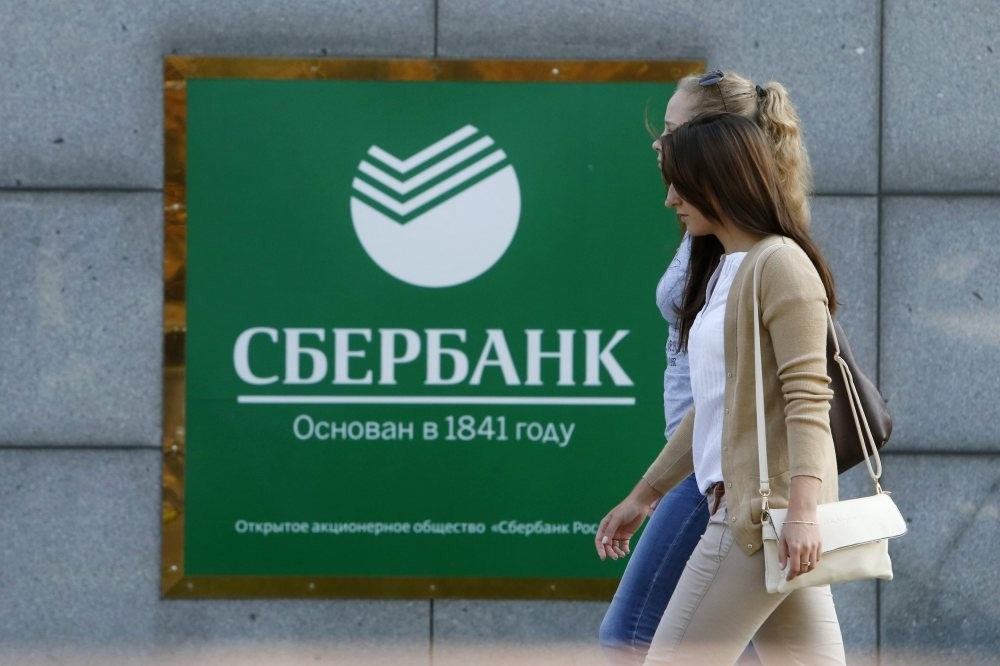 Women walk past an office of Sberbank in Moscow.