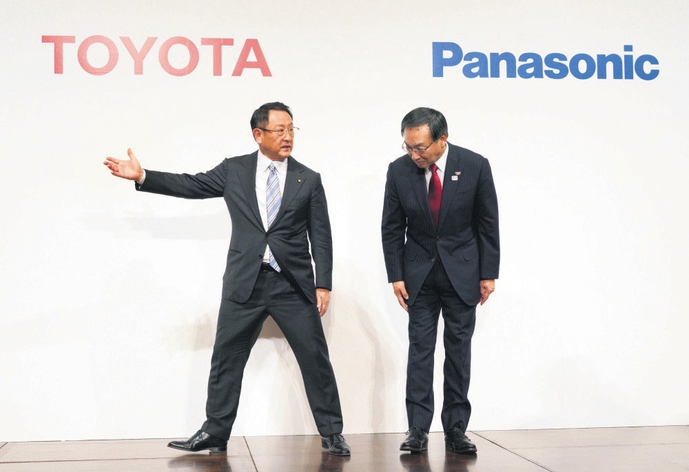 Toyota Motor Corporation President Akio Toyoda (L) escorts Panasonic Corporation President Kazuhiro Tsuga after a joint press conference yesterday in Tokyo.