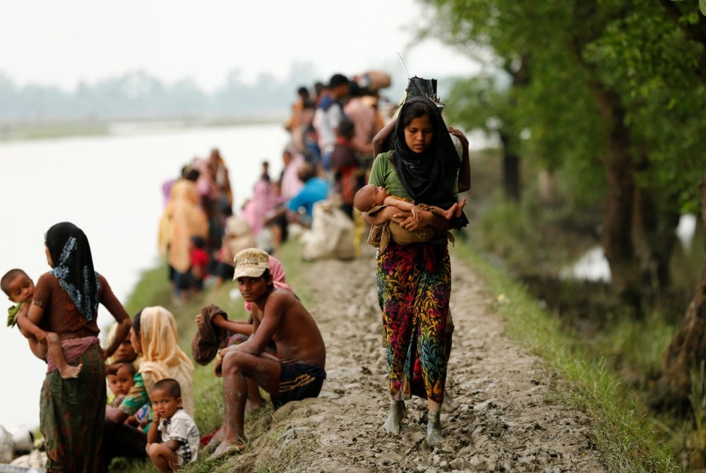 A Rohingya refugee woman with her child walks on a muddy path after crossing the Bangladesh-Myanmar border in Teknaf, Bangladesh, Sept. 7. 