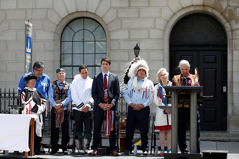 Canada's Prime Minister Justin Trudeau (C) listens to a prayer during an event announcing the creation of a new space for Indigenous Peoples at 100 Wellington Street (Reuters Photo)
