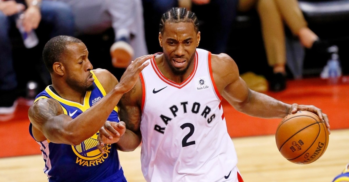Kawhi Leonard dribbles against Andre Iguodala during the third quarter in game five of the NBA Finals June 11, 2019.