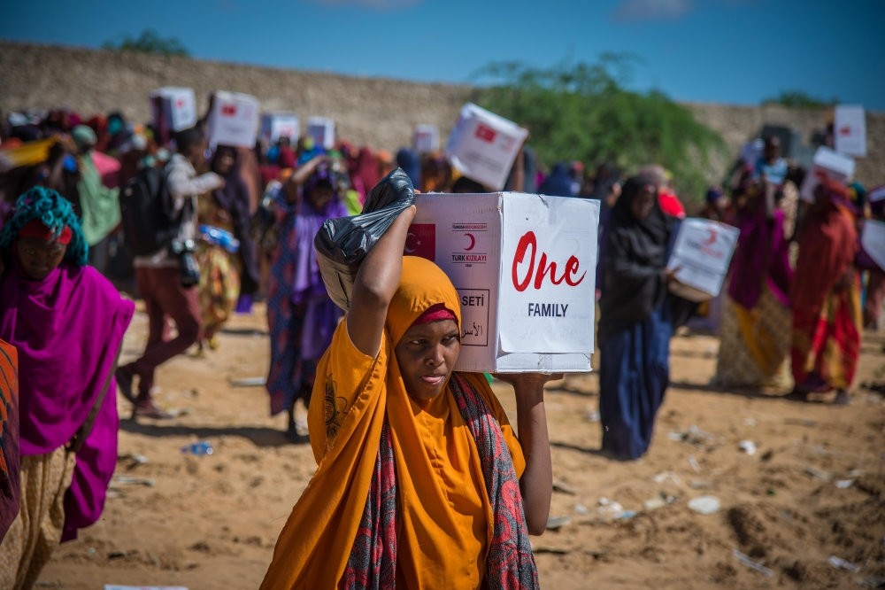 A Somalian woman carries a humanitarian aid delivered by Turkish Red Crescent during drought hit the country earlier this year. 