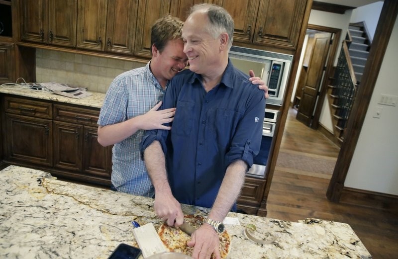 In this photo Saturday, April 1, 2017, Clay Heighten, right, gets a hug from his 19-year-old son Jon Heighten at their home in the Dallas area town of University Park, Texas (AP Photo)