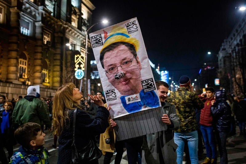 Protesters hold a poster depicting Serbian President Aleksandar Vucic during a demonstration against Serbian President Aleksandar Vucic in Belgrade on February 9, 2019 (AFP Photo)