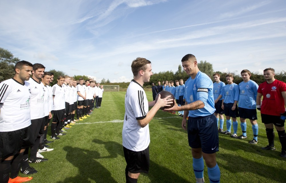 The team captains of Britain's Newark Town FC and Germany's FC Emmendingen exchange a football prior to a re-creation of the World War I Christmas Truce football match in Messines, Belgium.