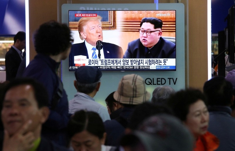 People watch a TV screen showing file footage of U.S. President Donald Trump, left, and North Korean leader Kim Jong Un during a news program at the Seoul Railway Station in Seoul, South Korea, Wednesday, May 16, 2018. (AP Photo)
