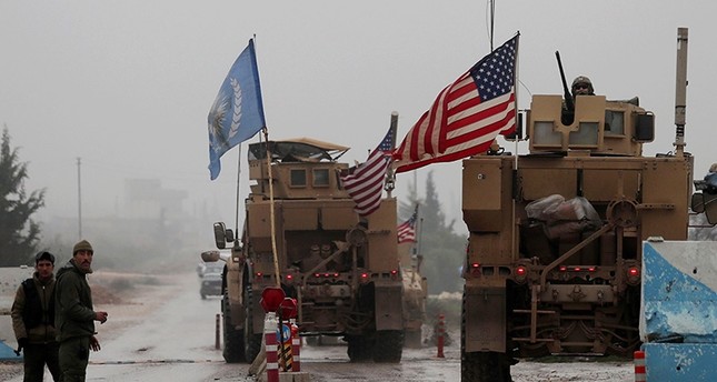 A line of US military vehicles drive through a checkpoint of the Internal Security Forces in Manbij as they head to their base on the outskirts of the northern Syrian city on Dec. 30, 2018 (AFP File Photo)