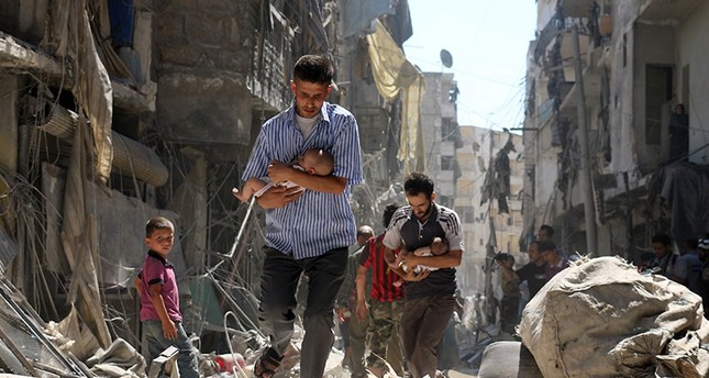 Syrian men carrying babies make their way through the rubble of destroyed buildings following a reported air strike on the oppositionl-held Salihin neighbourhood of the northern city of Aleppo (AFP File Photo)