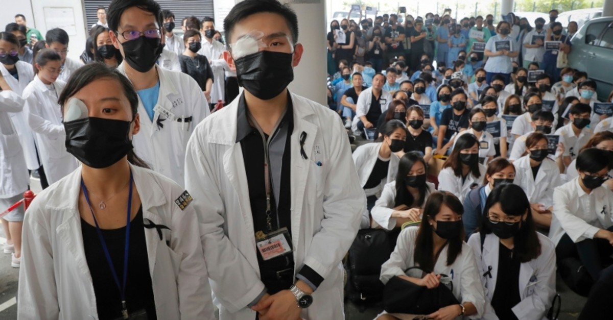 Medical staff wearing eyepatch and face masks take part in a protest against police brutality on the protesters, at a hospital in Hong Kong, Tuesday, Aug. 13, 2019. (AP Photo)
