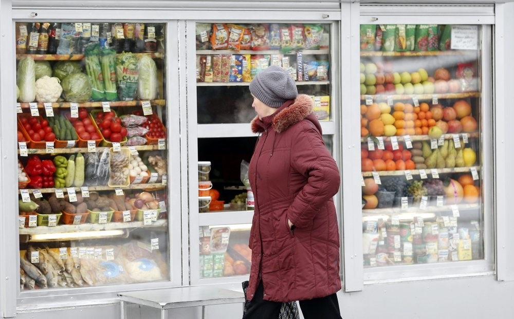 A Russian woman peers through the window to view fruits and vegetables at a street side market in Moscow.