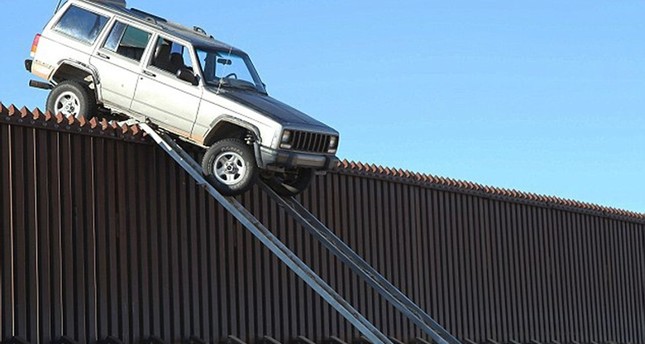 سيارة لمهربي مخدرات أثناء محاولتها اجتيار جدار فاصل بين المكسيك وولاية أريزونا الأمريكية