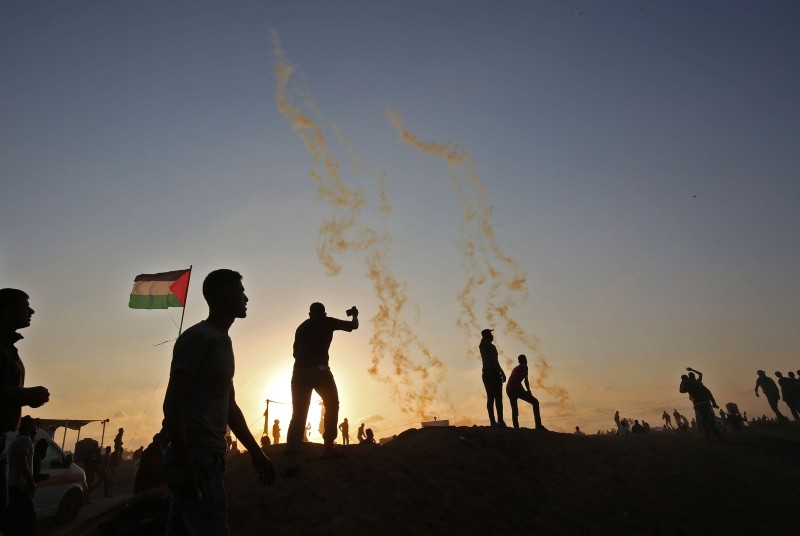 Palestinians protest as tear gas fumes erupt near the border with Israel, east of Khan Yunis, southern Gaza Strip, May 15.