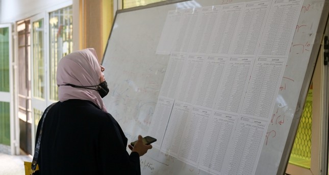 امرأة تراجع قوائم المرشحين للانتخابات في طرابلس رويترز