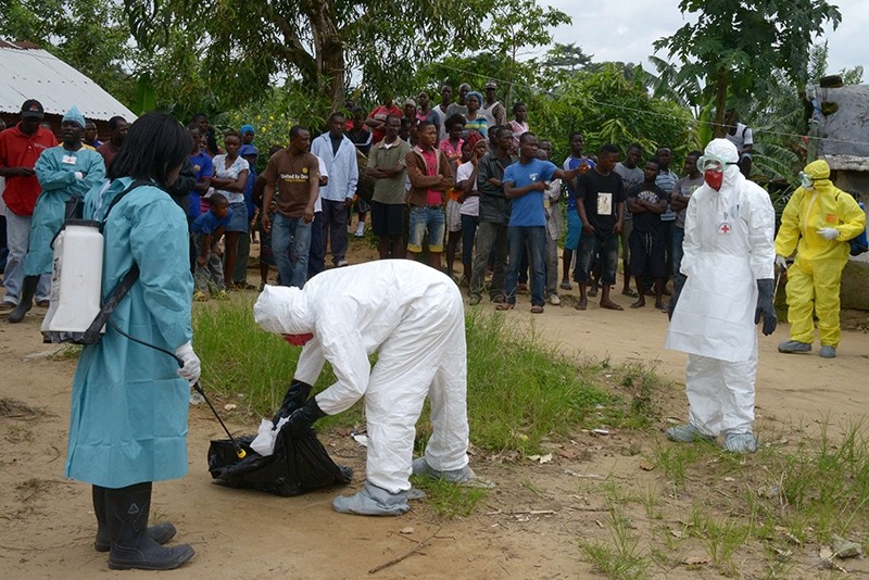 Liberian Red Cross health workers wearing protective suits intervene in a neighbourhood hit by the Ebola virus in Banjor on the outskirts of Monrovia on September 4, 2014 (AFP File Photo)
