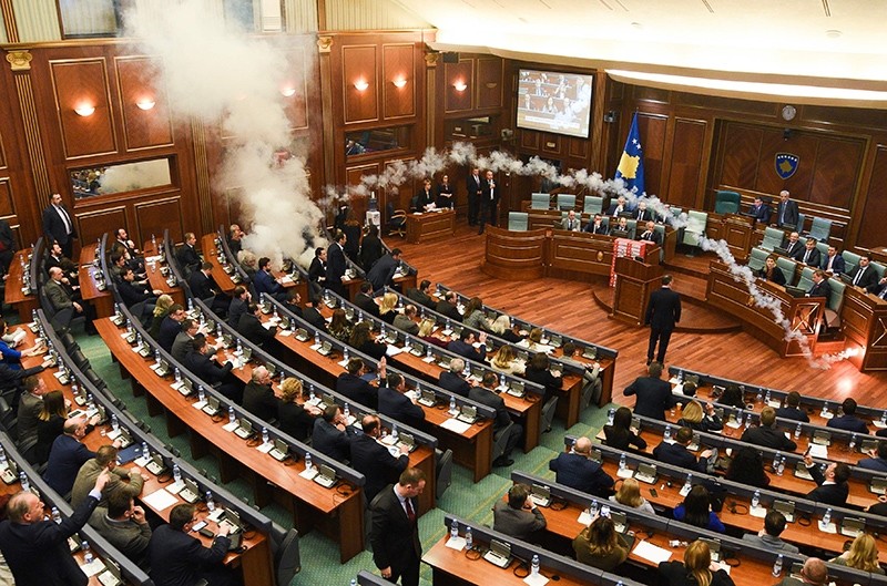 Opposition lawmakers throws a tear gas canister disrupting a parliamentary session in Kosovo capital Pristina on Wednesday, March 21, 2018. (AP Photo)