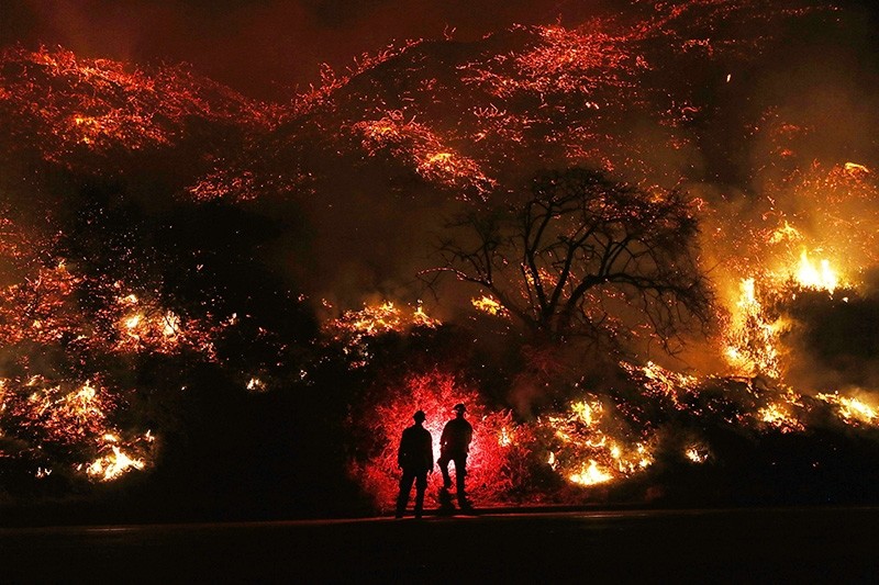 Firefighters monitor a section of the Thomas Fire along the 101 freeway on December 7, 2017 north of Ventura, California. (AFP Photo)
