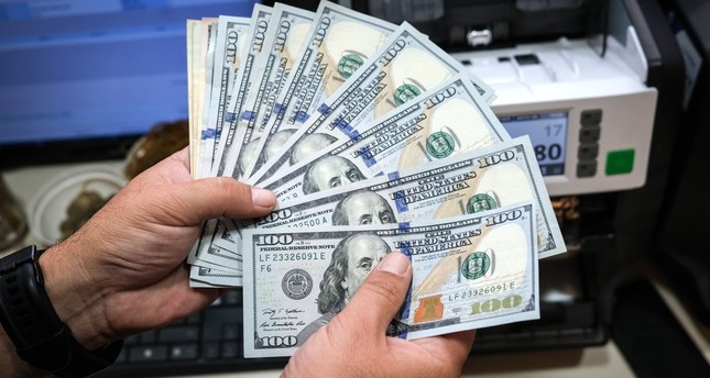 عامل يعد الأوراق النقدية بالدولار الأمريكي في أحد مكاتب الصرافة، إسطنبول، تركيا، 3-8-2023 صورة: EPA