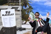 An Oxfam activist stages a satirical street-play mimicking a wealthy person hidding his money in a tax haven near the EU in Brussels, Belgium, Dec. 5, 2017. (AFP Photo)