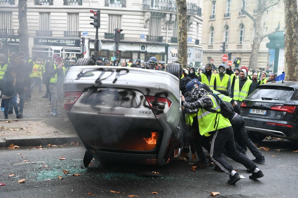 Demonstrators destroy a car during a protest on the Champs Elysees, Paris, Dec. 1.