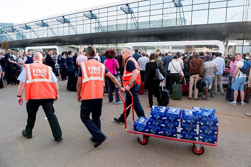 Firemen distribute water to waiting passengers after a power outage at Brussels Airport, in Zaventem, on June 15, 2017. (AFP Photo)
